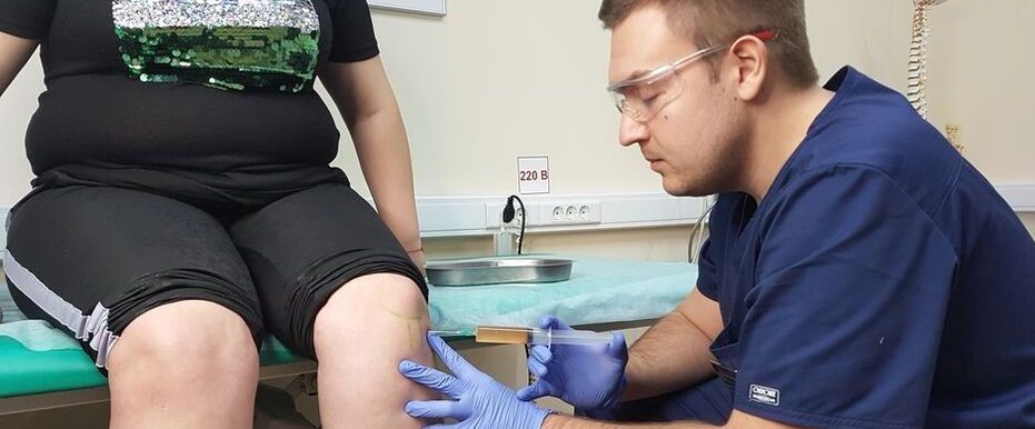 An orthopedic doctor makes an intra-articular injection into the knee joint for osteoarthritis