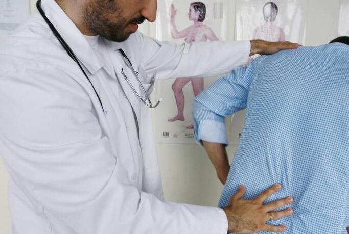 Doctor examining a patient with back pain in the lumbar region